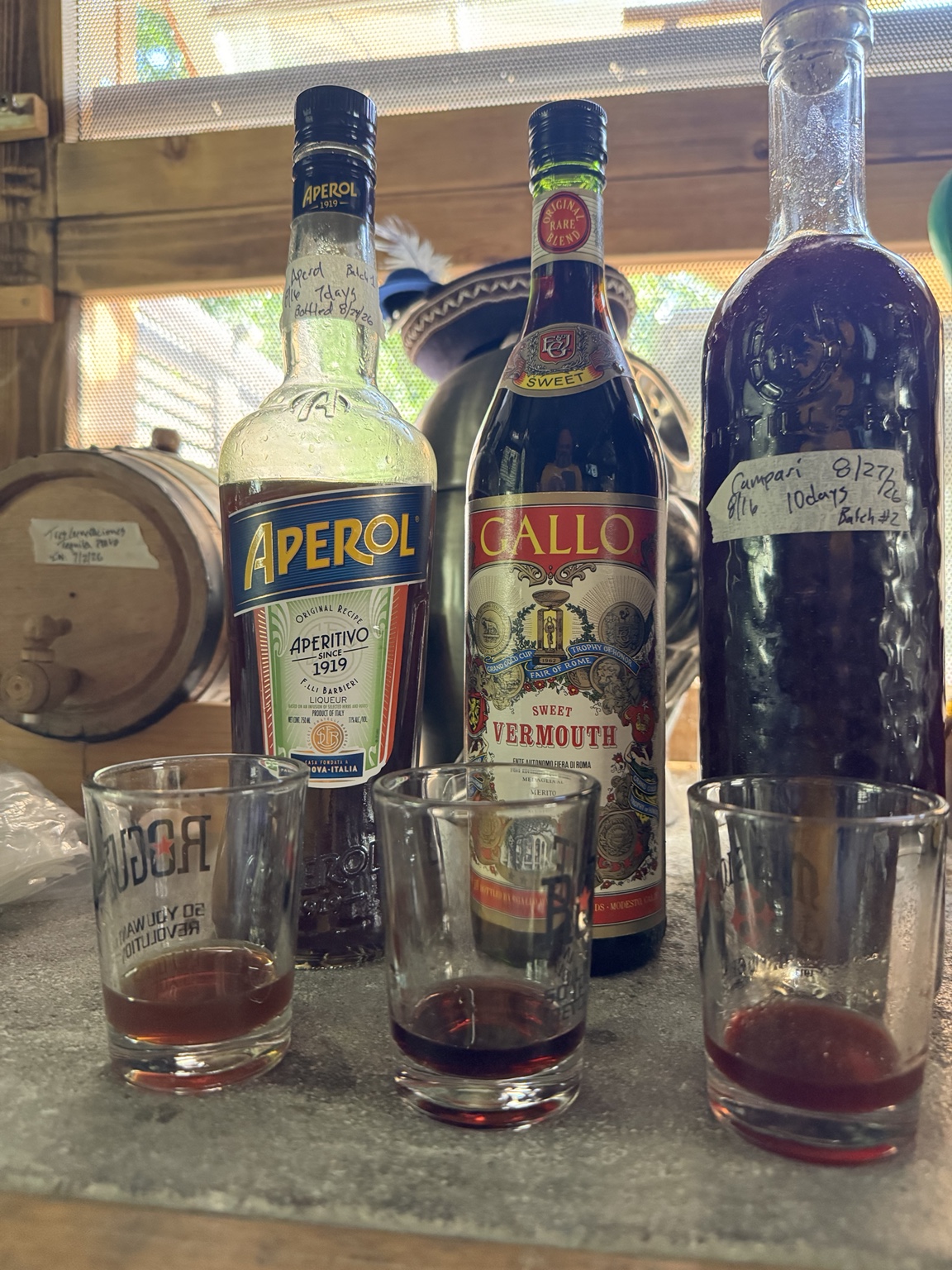 Three homemade aperitivi in reused bottles with tasting glasses in the Brewshed.